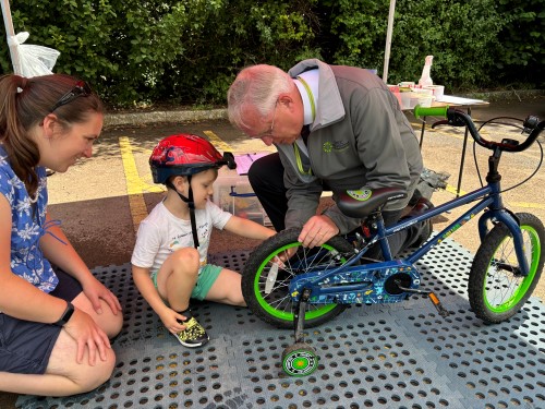 PCC helping child tag his bike.JPG